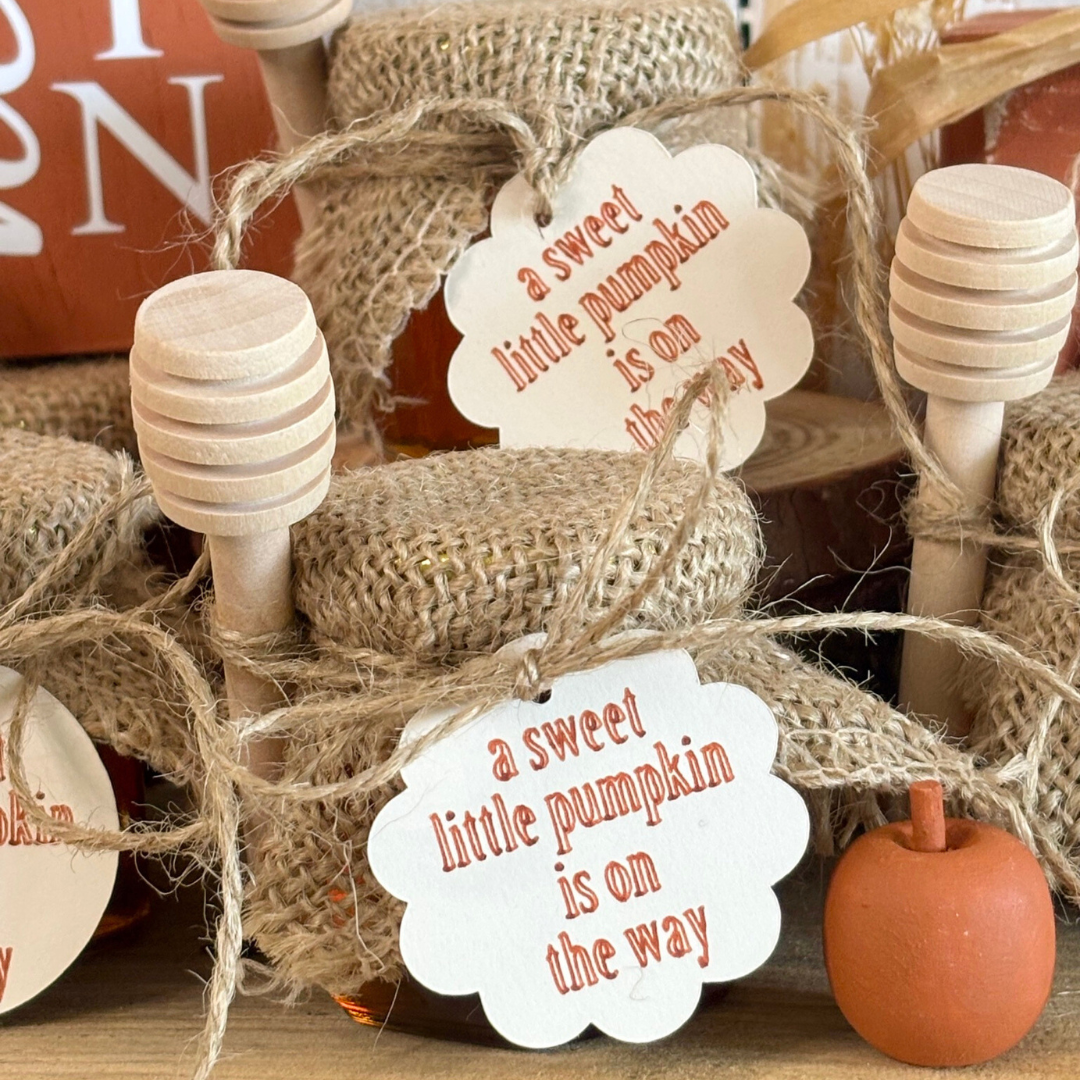 Decorative jars with burlap wrap and 'a sweet little pumpkin is on the way' tags.