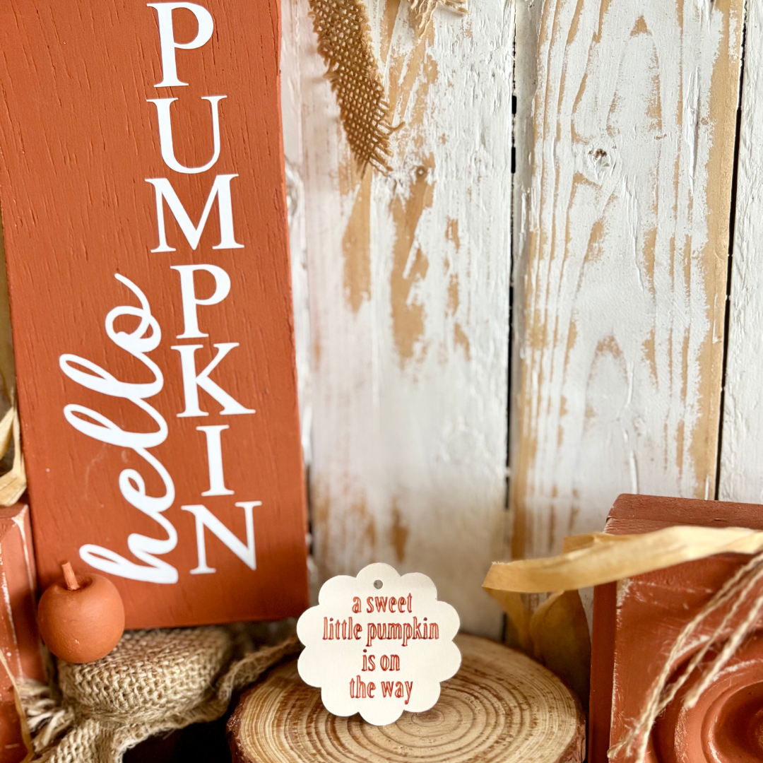 Wooden sign with 'Pumpkin Hello' text on a rustic background