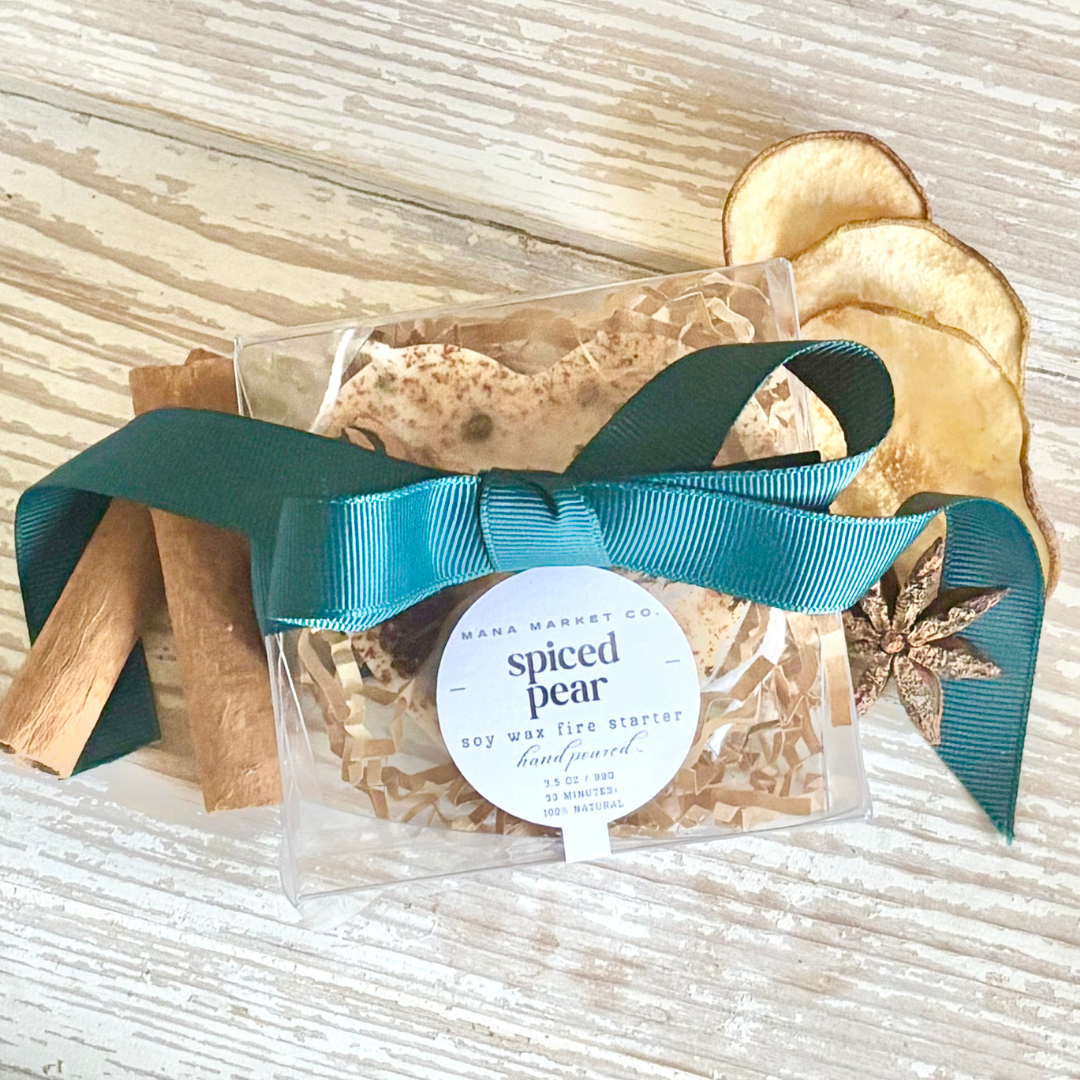 Packaged spiced pear wax melt with a teal ribbon on a textured surface