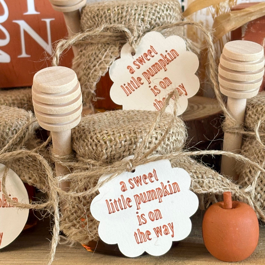 Decorative jars with burlap wrap and 'a sweet little pumpkin is on the way' tags.
