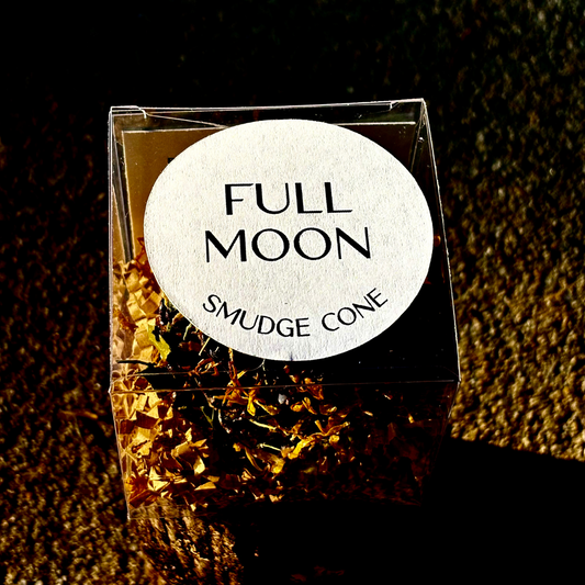 Full Moon smudge cone packaging with a label on a textured surface