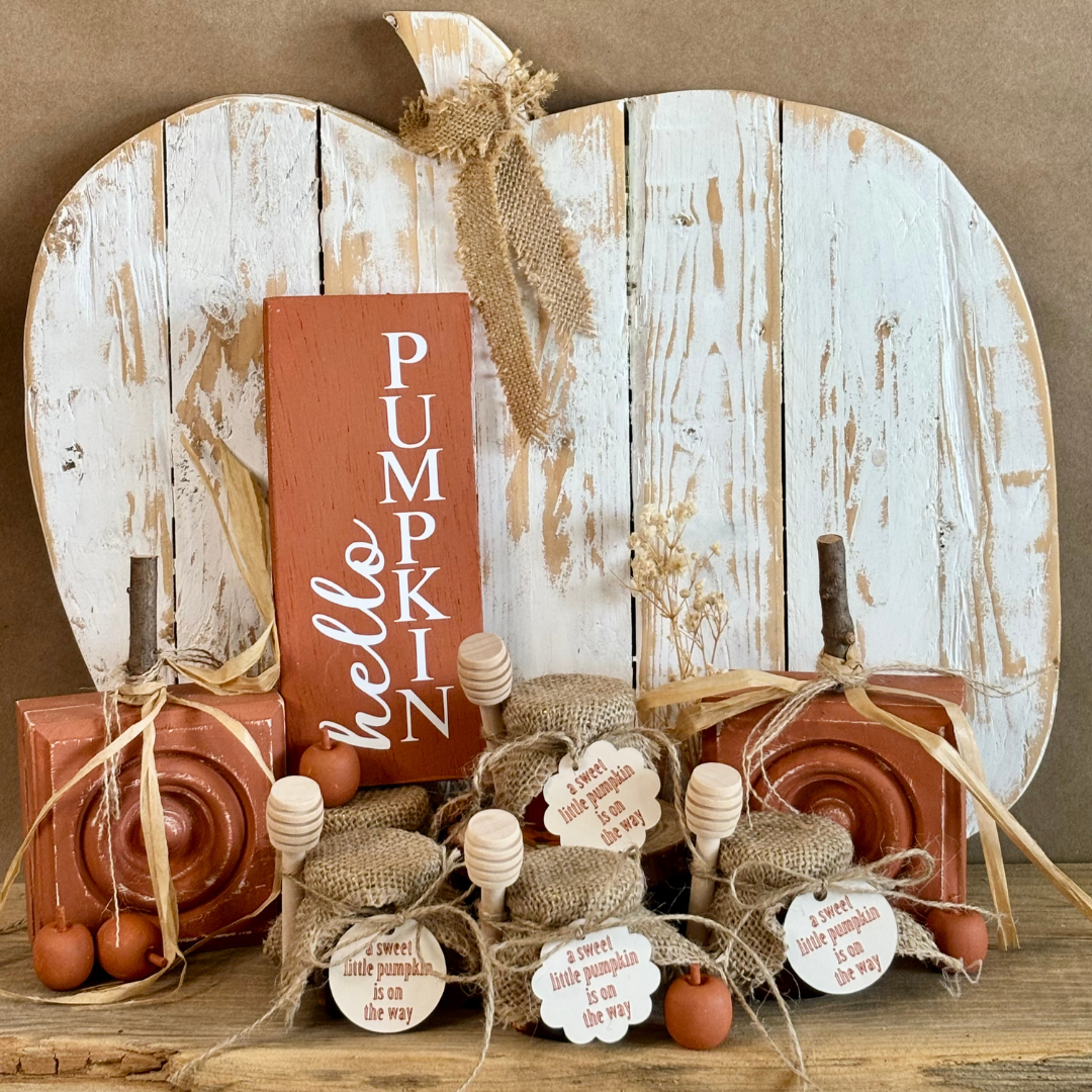 Decorative wooden pumpkins with a 'Pumpkin Hello' sign on a wooden surface.